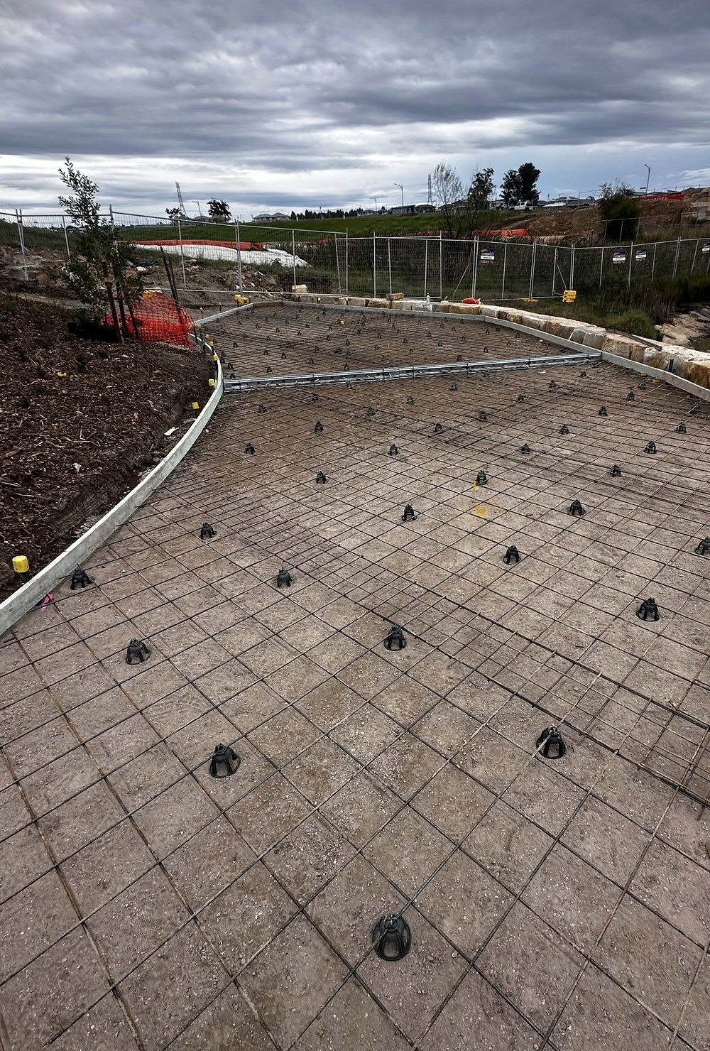 Mesh reinforcement laid, lapped, tied and chaired across a project site